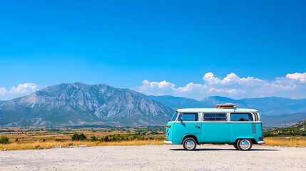 A blue camper van is parked on a mountain road, offering breathtaking views.