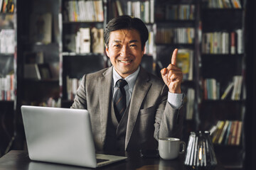 書斎・執務室・社長室にいる中年アジア人男性ビジネスマン（弁護士・役員・教授・法律事務所）
