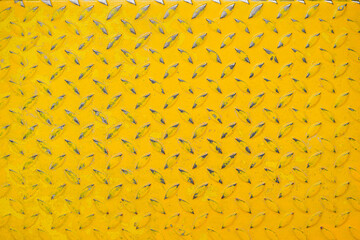 Yellow Floor. Top view of yellow painted metallic plate anti slip surface. Metal diamond plate texture. Closed up background pattern