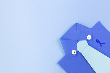 Handcrafted paper design of a blue shirt and tie on a blue background, promoting Men's Health Awareness Month. Ideal for Blue November and prostate cancer awareness campaigns