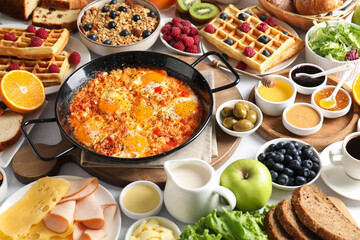 Different meals served for breakfast on white table