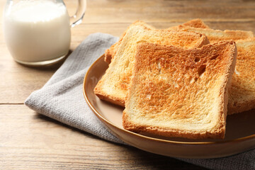 Delicious toasts served on wooden table, closeup