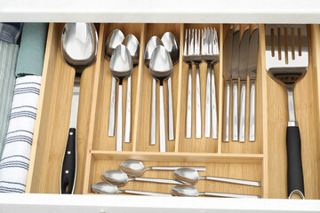 Box with cutlery in drawer, above view. Kitchen utensils storage
