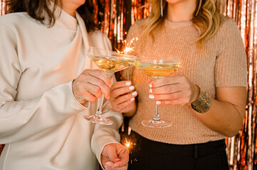 Women toasting with champagne and sparklers during festive event