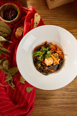 Fried Black Noodle Lagman with Vegetables in White Bowl on Wooden Table