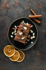 Roll cake in a bowl with dried oranges on a dark background