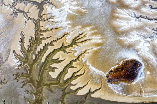 Aerial and morning view of snow covered mud flat and tidal channel at low tide at Hwangsando Island near Ganghwa-gun, South Korea 