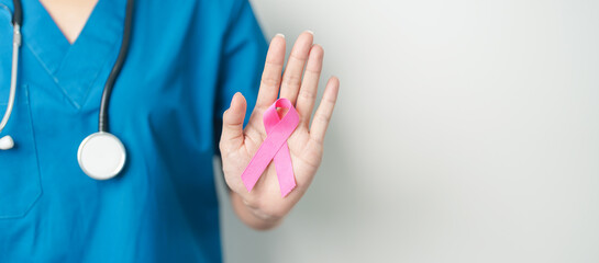 Pink October Breast Cancer Awareness month, woman doctor with pink Ribbon in hospital for support people life and illness. National cancer survivors month, Mother and World cancer day concept