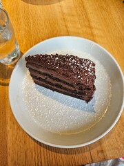 chocolate cake topped with powdered sugar on a plate