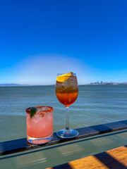 Enjoy refreshing cocktails by the waterfront with stunning ocean views and clear blue skies—perfect for summer vibes!
