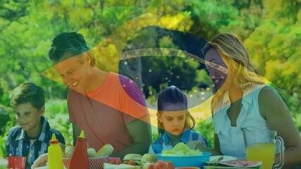 Animation of flag of brazil over caucasian family on eating in garden - Powered by Adobe