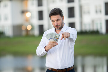 Attractive man is holding cash money in one hand. Joyful man with banknotes of money in his hands. Big financial luck and success, profit and cash. Rich man hands holding cash money