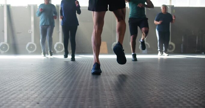 Coach, legs and group in gym with cardio, warm up and jog together for fitness in retirement. Person, mentor and elderly people with steps, advice and running with shoes to start workout for health