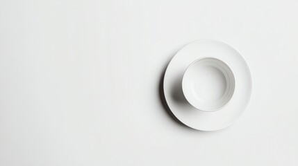 An empty bowl and plate on a white surface.