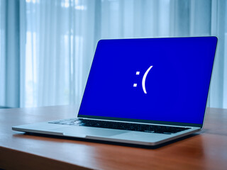 System error concept. Blue screen of death or BSOD showing, big sad emotion face, emoticon on blue...