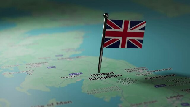 A small Great Britain flag is pinned on a map of Great Britain.