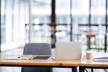 Shot of light cozy laptop computer office interior in modern minimalist style with working desks and plants, copy space