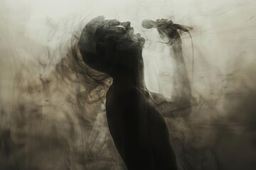 Fototapeta premium Dynamic silhouette of a passionate singer expressing emotion while holding a microphone amidst swirling smoke.