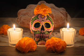 Day of the Dead altar decoration with skulls, bread of the dead, and paper cenpasuchil flowers.