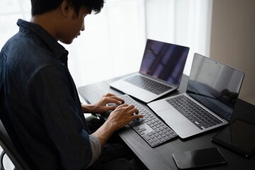 Asian man software engineer Working on Computer at office desk for writing program code IT Software Engineer finding errors tech support devops creating digital