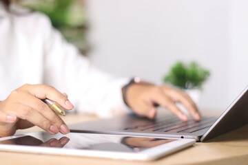 Business woman working on laptop computer with digital tablet on office table. searching the information, freelance lifestyle. Female freelancer busy working on laptop, surfing the internet,