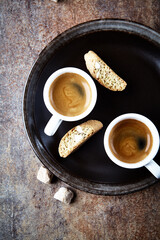 Cantuccini (Italian cookie) and Two Cups Of Coffee on rustic stone background. Top view. Copy space.	