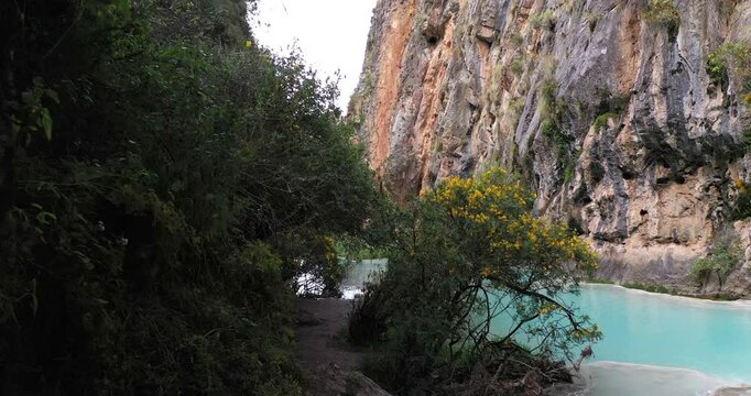 Beautiful first person shot walking through the vegetation to reach the famous Millpu Lake of Ayacucho Peru with turquoise water.