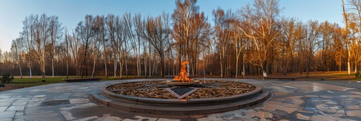 Eternal flame within a memorial space surrounded by birch trees and a star design with flames on a bright day.