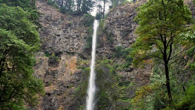 Slow motion landscape view of Multnomah Falls bridge with river running tourism travel in Oregon Columbia Gorge National Park USA America nature outdoors valley