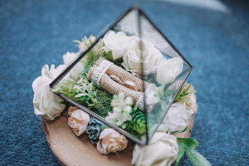 A couple of wedding rings on the triangle box at wedding ceremony on blue background