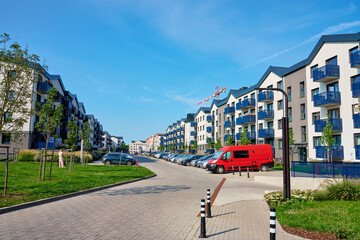 Modern apartment building with balconies and green trees on sunny day. Residential complex in Wroclaw, Poland. Mortgage in real estate