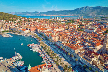 Obraz premium Aerial view of Split, Croatia. Cityscape of coastal touristic city with harbor with mountains in background. Old town with historical red roof tiled buildings near Adriatic Sea
