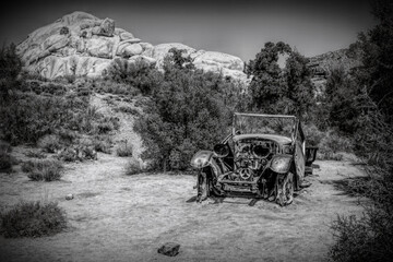 An old abandoned car sits derelict and rotting on the Wall Street Mill Trail in Joshua Tree National Park, California.