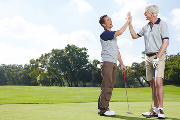 Game, high five and men on golf course together for teamwork, outdoor fun and happy competition at club. Sports, senior father and son on green with motivation, bonding and support for partnership