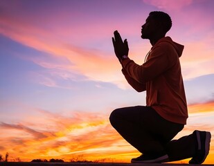 Silhouette of a person praying at sunset with vibrant skies and mountains in the background