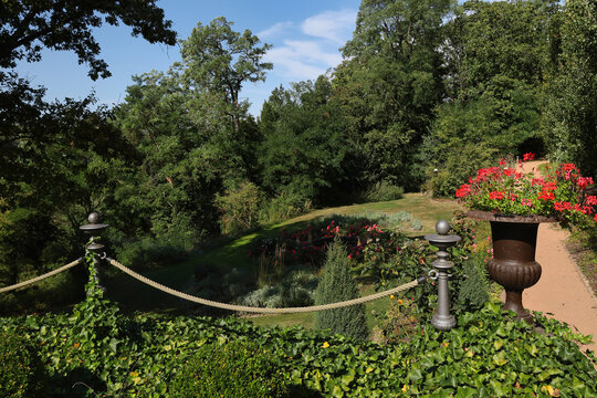 Idyllischer Parkweg am Rittergut K&ouml;ssern mit bl&uuml;henden Blumenk&auml;sten, mediterranen K&uuml;belpflanzen und dichtem Baumbestand im Sommer, Rittergut K&ouml;ssern, Grimma, Landkreis Leipzig, Deutschland