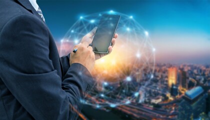 A businessman in a suit uses a stylus on a smartphone against a backdrop of a city skyline with a glowing network overlay.