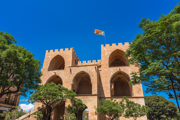 Fototapeta premium Valencia, Spain. Rear view of the Torres de Serranos, an old gate on the city's walls with a Regional Valencian Flag on top of them