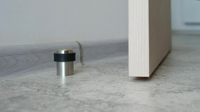 Close-up a stainless steel door stopper in a house or office.