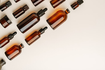 Various Amber Glass Containers for Essential Oils and Skin Care Products Displayed on Light Background