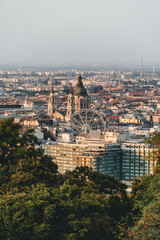 city panorama with big cathedral basilica on sunset light with two imponent towers and huge dome and wheel of the city 