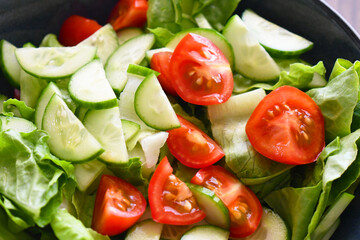 Vegetable salad with cucumber, lettuce and cherry tomatoes. Summer vegetables salad. Healthy and dietary food. 