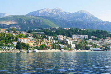 Fototapeta premium View from the Bay of Kotor to the Savina area in Herceg Novi and the mountain village of Podi. Landscape from the Montenegrin coast: the waters of the sea, Mount Orjen and the city between them.