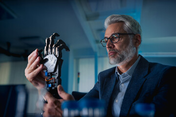 Robotics engineer adjusting, calibring robotic prosthetic hand. Concept of modern technology in medicine. Robotic prosthetics, biomechatronics and neuroscience.