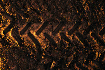 Pattern of tractor tire track imprint in dirt road dried muddy ground