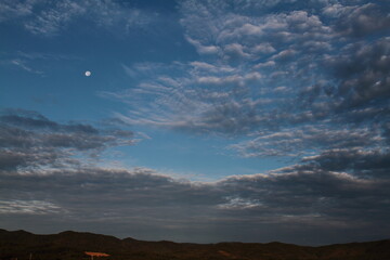雲の隙間からまるい月　左