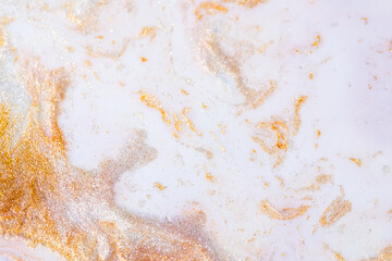 Colorful liquid paint abstract background. White and pink acrylic paints with golden glitter