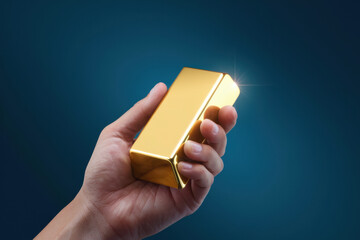 Hand Holding Shiny Gold Bar Against Blue Background, Symbolizing Wealth and Investment