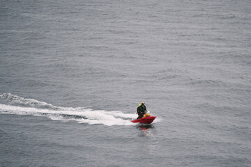 Unrecognizable Lifeguard patrolling on a rescue water scooter in the sea