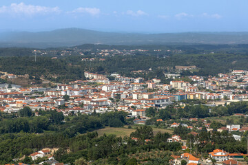 Obraz premium Cityscape of Ourém from the castle, houses, apartments and lots of greenery and mountains in the background with windmills